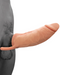 A realistic silicone prosthetic penis, known as The Great Extender 2 in 1 8 Inch Penis Extender and Stroker - Vanilla by Nasstoys, is shown attached to a person's body. The prosthetic is flesh-colored and extends outward, blending naturally with the skin. The background appears to be a neutral, grayish tone.