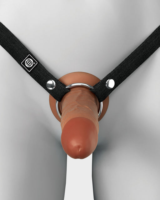 A close-up view of the Fantasy X-Tensions Elite Hollow 6 Inch Silicone Dildo & Strap-On Harness - Chocolate by Pipedream Products, secured with a black harness. Crafted from dual-density silicone, it features realistic, chocolate-toned male genitalia and is designed to fit around the waist and groin area, with the lifelike phallic part positioned at the front.