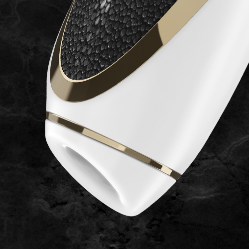 Close-up of the Satisfyer Luxury Air Pulsation + Vibration, featuring a sleek and modern design with a textured gold and black leather surface. Its ergonomic handle complements its cylindrical shape with a rounded end, set against a dark, marble-like background.