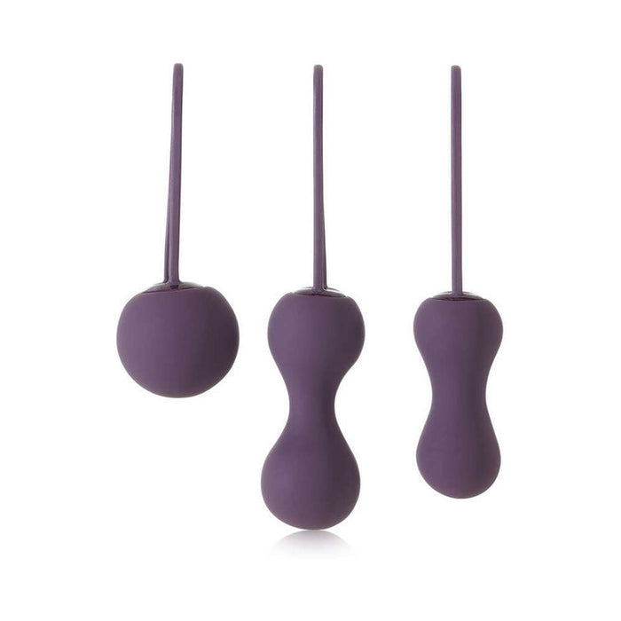 Explore the Je Joue Ami Kegel Ball Exerciser Set in purple, a three-piece silicone system to enhance pelvic floor strength. It includes a round, a double-ball, and an elongated ball, all featuring smooth surfaces and retrieval cords for easy use.