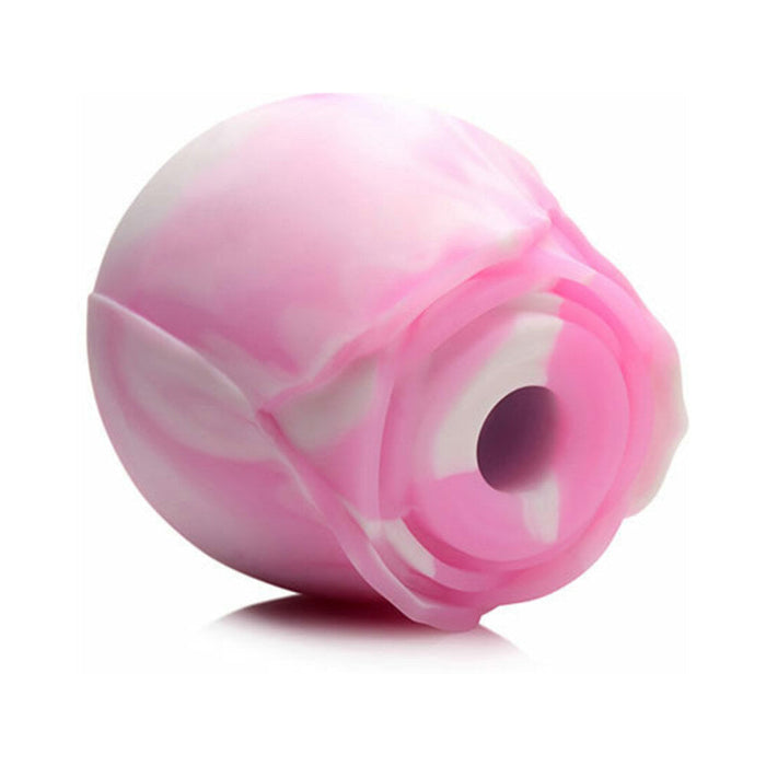 The Rose Dream Pink Swirl Powerful Clitoral Stimulator by XR Brands is a pink and white spherical object with a floral design, featuring a central hollow opening. Made of body-safe silicone, it provides clitoral stimulation. The stimulator has a smooth, glossy finish and appears soft and flexible. It is set against a plain white background.