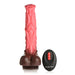 A textured, pink and brown Deluxe Centaur 10 inch Vibrating & Thrusting Silicone Fantasy Horse Dildo from XR Brands stands upright next to a black, oval-shaped remote control. The remote has a red button and additional control buttons, with the text "CREATURE COCKS" printed below them. This unique piece includes realistic thrusting vibration for an enhanced experience.