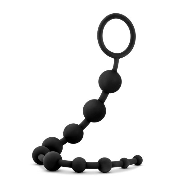 The Anal Adventures 10 Silicone Anal Beads by Blush feature a set of black, body-safe silicone beads, designed with a loop handle at one end for easy retrieval. Each bead increases gradually in size along the length of the toy, arranged in a curving line against a plain white background to ensure both safety and comfort for users.