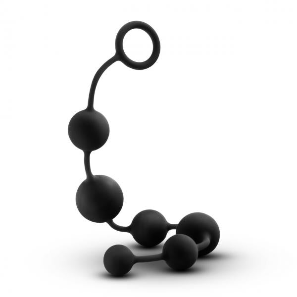 The Anal Adventures Silicone Large Anal Beads by Blush feature a black, flexible string of silicone beads with a loop handle on one end. The beads vary in size and are arranged in ascending order from the smallest to the largest. Waterproof and designed for enhanced anal sensations, these beads stand on their own in a spiral-like shape.