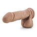 A realistic-looking, caramel-toned Blush Au Naturel 8 Inch Dual Density Suction Cup Dildo with Balls, featuring detailed texture and attached testicles, is displayed on a plain white background.