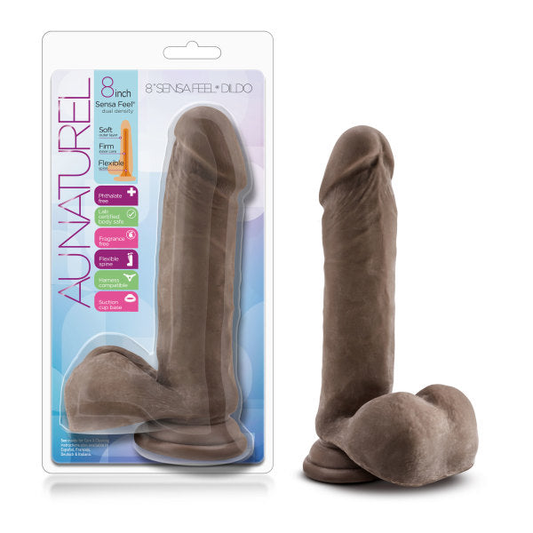 A packaged chocolate-colored Au Naturel 8 Inch Dual Density Suction Cup Dildo with Balls by Blush is displayed. The label states it is 8 inches long, soft, firm, flexible, and has a realistic shape with a pronounced head and textured surface. Designed for versatility, it features a strap-on compatible suction cup base.