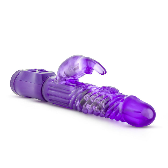 Introducing the B Yours Beginner Bunny Rabbit Vibrator by Blush – a translucent purple adult toy designed with a rounded, textured tip and a small, rabbit-shaped extension for additional stimulation. This phthalate-free vibrator features ribbed and beaded details along the shaft, offers multiple vibration settings, and includes an easy-to-use control panel at the base.