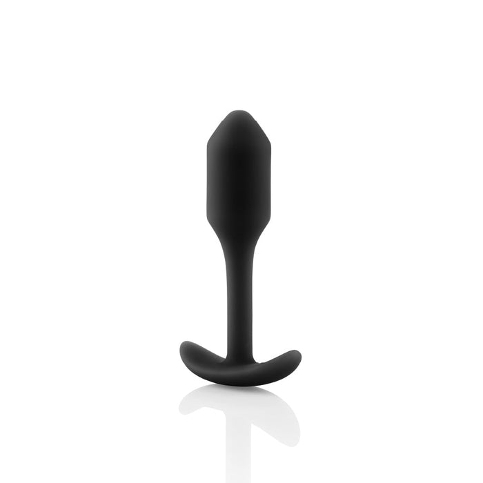 A black, silky silicone b-Vibe Snug Plug 1 Weighted Butt Plug, weighing 2 oz and featuring a smooth surface and a T-shaped base, displayed against a white background. The sleek design reflects simplicity and functionality, while its waterproof feature adds practicality.