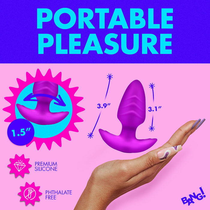 A vibrant promotional image shows a hand holding a purple silicone pleasure toy with dimensions indicated: 3.9 inches and 3.1 inches. The text reads, "PORTABLE PLEASURE" and mentions "Silky Smooth Silicone" and "Phthalate Free." The brand name "XR Brands BANG! Rotating & Vibrating Silicone Butt Plug with Remote" is displayed.