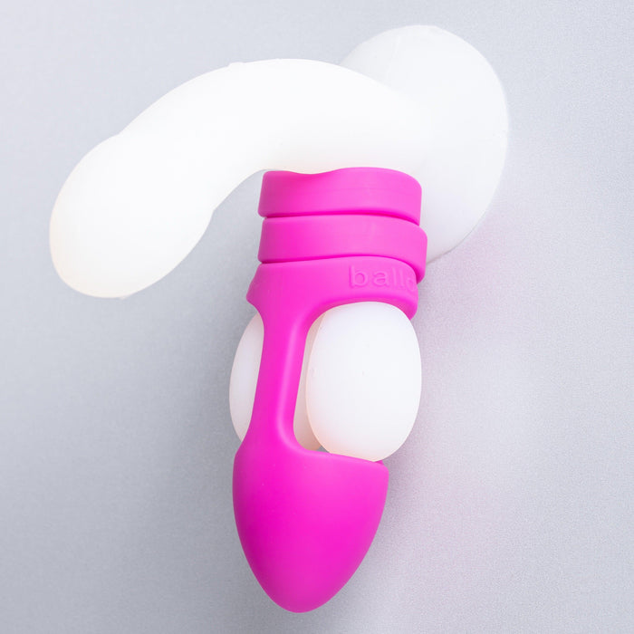 A purple silicone product branded as Balldo, which features a suction cup to secure it to a smooth surface, boasts a bulbous section at the bottom and an elongated form above. Aptly named Balldo: The World's First Ball Dildo, it appears to be a well-designed adult toy.