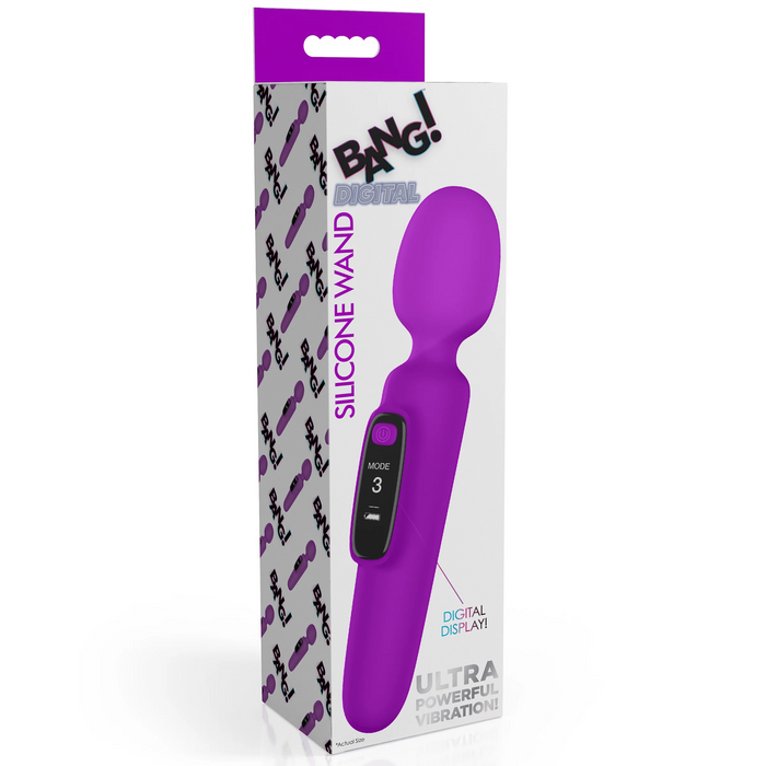 The image displays a boxed product named "Bang! First Time Wand Vibrator with Digital Display - Purple." The packaging features a picture of a rechargeable purple silicone wand vibrator with a digital screen showing "Mode 3." The box's design includes the brand name, XR Brands, and phrases such as "Ultra Powerful Vibration!