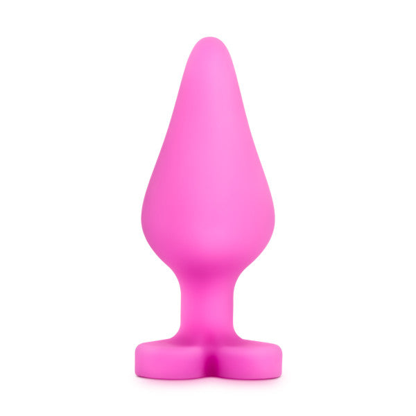 The Be Mine Naughty Candy Heart Butt Plug - Pink by Blush is a charming pink hue silicone butt plug, crafted with a bulbous body that narrows to a point and flares out at the base. Ideal for anal beginners, this heart-shaped plug adds a touch of whimsy and comfort.