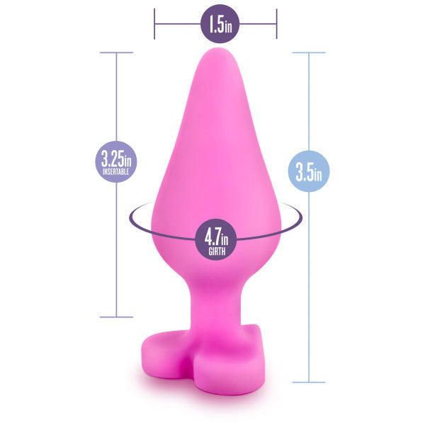 The Be Mine Naughty Candy Heart Butt Plug - Pink by Blush is a soft silicone, heart-shaped butt plug shown with measurements: a height of 3.5 inches, girth of 4.7 inches, insertable length of 3.25 inches, and a width of 1.5 inches at the widest point. Ideal for anal beginners, it features a unique base shaped like feet.