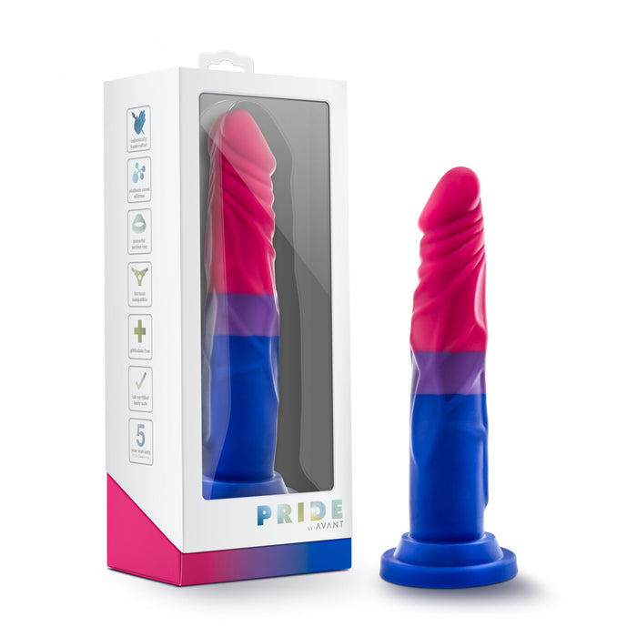 A colorful Blush Bisexual Pride 7.5 Inch Silicone Suction Cup Dildo stands upright next to its packaging, proudly showcasing the colors of the bisexual flag in pink, purple, and blue. Made from premium platinum cured silicone, this toy features a suction cup base for versatile use. The box matches the color theme and prominently displays the "Blush" brand name.
