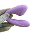 A hand delicately holding the Blaze Air Pulsation and G-Spot Bendable Double Ended Vibrator in purple by Nasstoys.