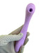 A gloved hand holding the Nasstoys Blaze Air Pulsation and G-Spot Bendable Double Ended Vibrator in a sleek purple.