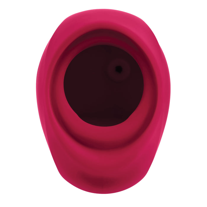 A close-up view of the pink silicone rubber ring from the Body Kisses Red Suction Masturbator and Vibrator by Evolved Novelties, featuring a hole in the center and showcasing its smooth, curved edges.