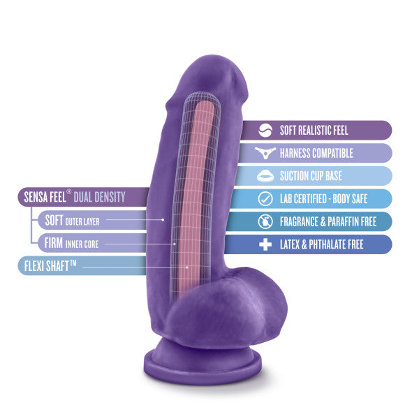 The Bold Beefy 7 Inch Dual Density Suction Cup Dildo in Purple from Blush is showcased in a detailed graphic that highlights its key features. Arrows point to descriptors such as "Sensa Feel™ Dual Density," which indicates a soft outer layer and a firm inner core. Additional features include a powerful suction cup base, harness compatibility, and being free from latex, fragrance, and phthalates.