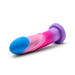 The Borealis Dreams 7.75 Inch Girthy Silicone Dildo - Cotton Candy from Blush features a colorful design with a blue tip transitioning into pink and ending in a purple base. The toy has a smooth texture, a slightly curved shape, and includes a suction cup for added versatility. It is positioned horizontally on a white background.