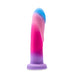 The Borealis Dreams 7.75 Inch Girthy Silicone Dildo - Cotton Candy by Blush features a flexible, realistic design with a captivating gradient of bright colors that transitions from blue at the top to pink and finally ends in purple at the base. This versatile toy is perfect for use with a strap-on harness and includes a suction cup for hands-free play.