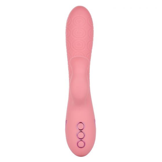 The California Dreaming Pasadena Player G-Spot Rabbit Vibrator by CalExotics is a pink, textured personal massager featuring a smooth central portion and three purple control buttons near the base. Designed with ergonomic contours for ease of use, this rabbit vibe also includes a g-spot arm for enhanced pleasure.