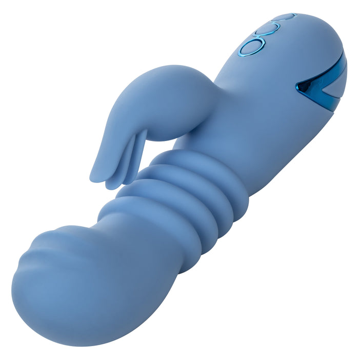 The California Dreaming Santa Cruz Coaster Thrusting G-Spot Rabbit Vibrator by CalExotics is a light blue, ergonomically designed personal vibrator featuring ribbed sections and a curved clitoral arm. It has blue control buttons and a shiny accent near the top, indicating its electronic nature.