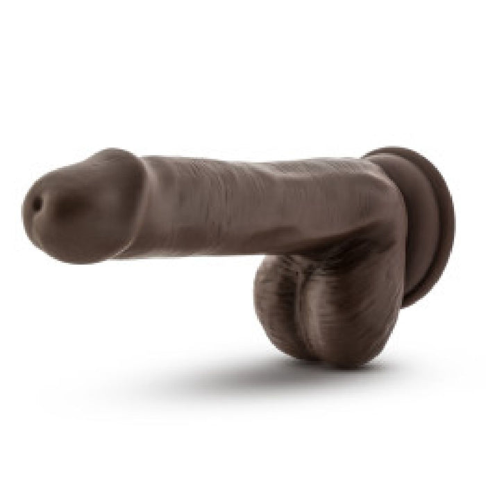 A Blush Coverboy Top Gun Tommy 6 Inch Dildo in chocolate, featuring realistic skin texture detail on the shaft and testicles, displayed on a white background.