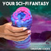 A hand holding the Cyclone Squishy Alien Vagina Role Play Stroker by XR Brands, a colorful, textured object with pink and blue hues that resembles a fantasy sci-fi creature crafted from premium silicone. The background features an otherworldly landscape with mountains and a starry sky. Text at the top reads: "Your Sci-Fi Fantasy" and at the bottom right: "Creature Cocks".