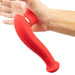 A hand holding the Destiny Red Clitoral Suction Vibrator with Tongue by Maia Toys, an ergonomic, curved silicone object with a glossy ring near the base. The tool is positioned against the palm, demonstrating its shape and grip and resembling a waterproof clitoral sucking toy.