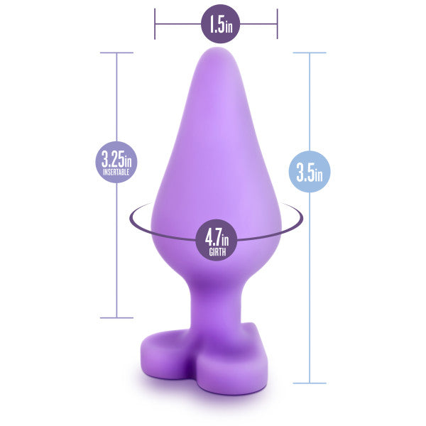 Introducing the Do Me Now Naughty Candy Heart Purple Butt Plug by Blush—a purple, cone-shaped silicone sex toy with a flared base that's perfect for anal beginners. This toy measures 1.5 inches at its widest point, 3.25 inches of insertable length, and has a total height of 3.5 inches with a girth measurement of 4.7 inches.