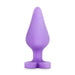 The Do Me Now Naughty Candy Heart Purple Butt Plug by Blush is a teardrop-shaped, hypoallergenic, phthalate-free silicone butt plug that stands upright, featuring a smooth surface and a flared base.