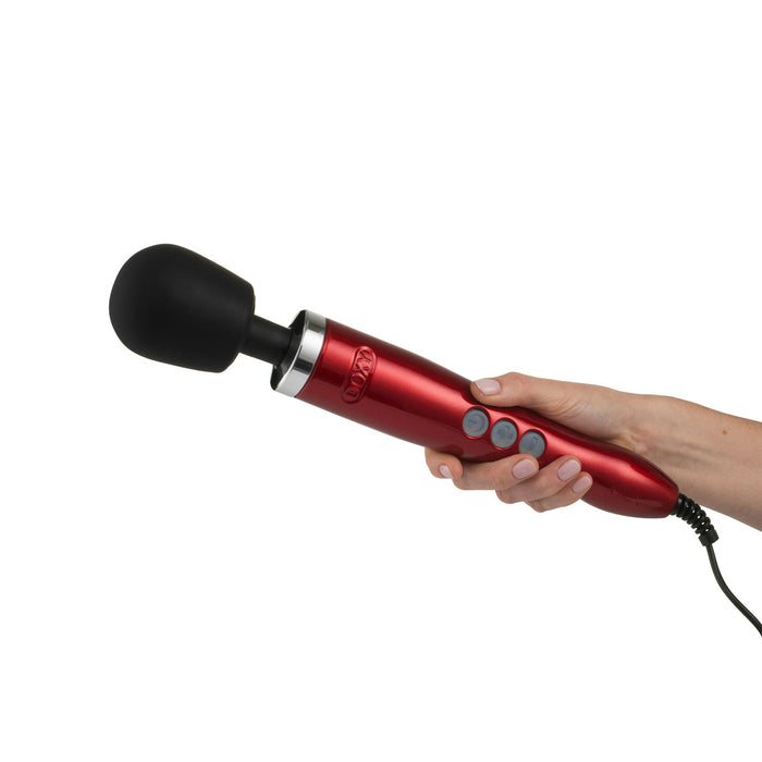 A person holding a Doxy Die Cast Extra Powerful Wand Vibrator - Red, featuring a black rounded head, a narrow handle, and several control buttons on the side. The luxurious massager by Doxy delivers deep rumbly vibrations and is connected to a power cord.