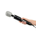 A hand holding the Doxy Extra Powerful Wand Vibrator - Black from Doxy, featuring a rounded, grey attachment made of medical quality silicone. The massager has several buttons on its handle for adjusting settings and is connected to a cord.