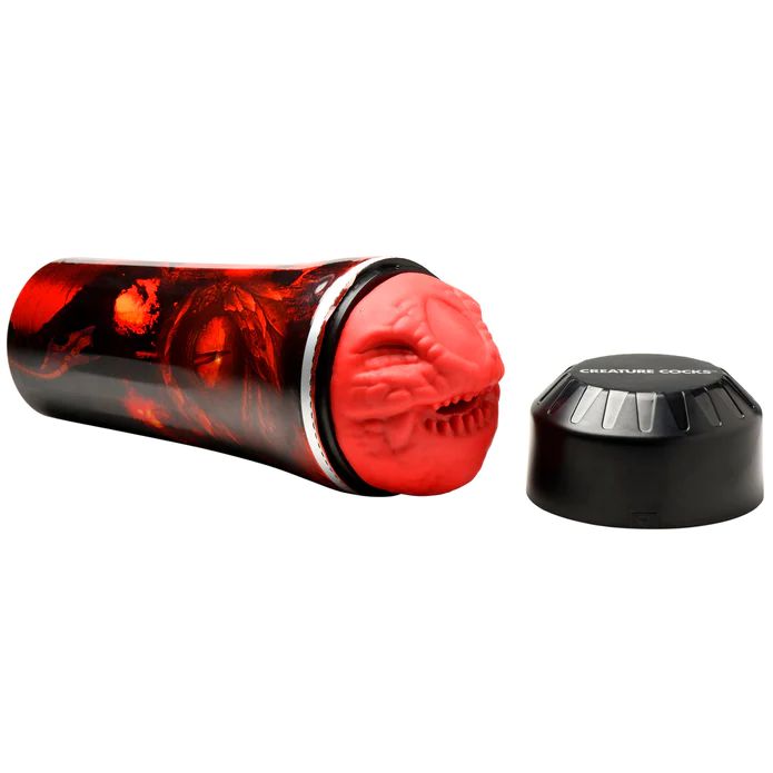 A cylindrical red and black object with a detached lid labeled "Dragon Snatch Stroker Fantasy Role Play Stroker" by XR Brands sits beside it. The exposed end of the cylinder, reminiscent of a Dragon Snatch Stroker, features a grotesque, creature-like face.