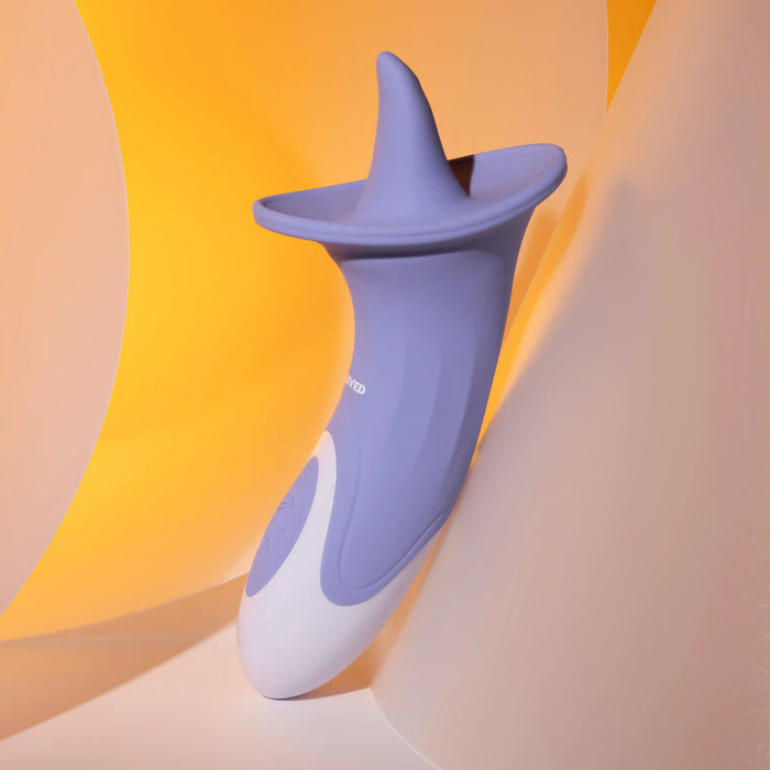 A purple and white tech gadget with a sleek, curved design is displayed against a softly lit yellow and white backdrop. The Lix & Kisses Swirling Tongue Oral Sex Vibrator by Evolved Novelties features a flared, conical top and a smooth, ergonomic body made from phthalate-free silicone.