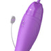 A close-up of the Fantasy For Her Ultimate Pleasure Max Licking Sucking Vibrator by Pipedream Products, featuring a sleek purple design with a smooth surface. It has two small metal contact points on one side and includes a white cord attached to a white circular component with two small holes, reminiscent of the design of a double-ended vibrator.