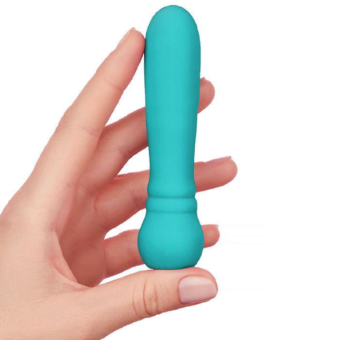 A hand holding a small, turquoise FemmeFunn ULTRA BULLET Powerful Silicone Vibrator. Crafted from premium silicone, the device boasts a smooth, rounded design with a larger base. This waterproof and powerful bullet vibrator stands out against a pristine white background.