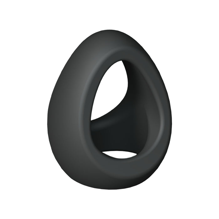 A sleek, egg-shaped object in black with a smooth texture and a central opening, resembling an abstract modern sculpture or a minimalistic decorative piece. Standing upright against a plain white background, it subtly reveals itself as the Flux Stretchy Black Silicone Cock and Ball Ring by Lovely Planet.