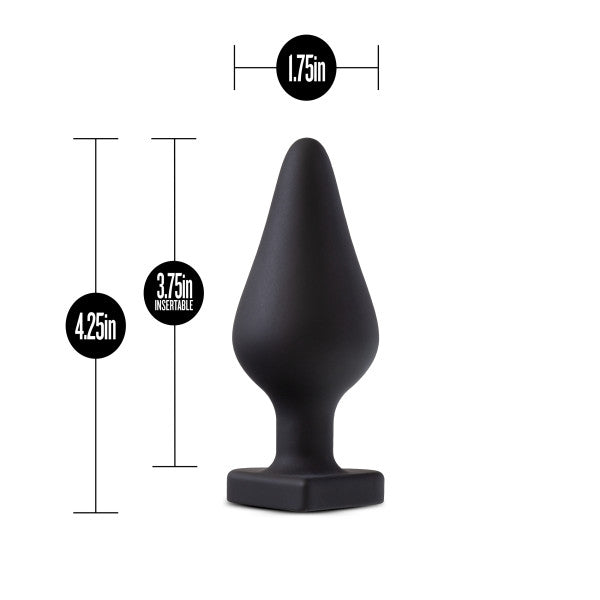 The Fuck Me Silicone Heart Butt Plug - Black by Blush is displayed. It features a bulbous shape with a tapered tip and a heart-shaped base for added charm and safety. The dimensions are 4.25 inches in total length, 3.75 inches insertable length, and 1.75 inches at the widest point.