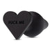 A black, heart-shaped Fuck Me Silicone Heart Butt Plug by Blush, featuring the phrase "FUCK ME" engraved on it. Made of smooth and flexible silicone material, it has a heart-shaped base.