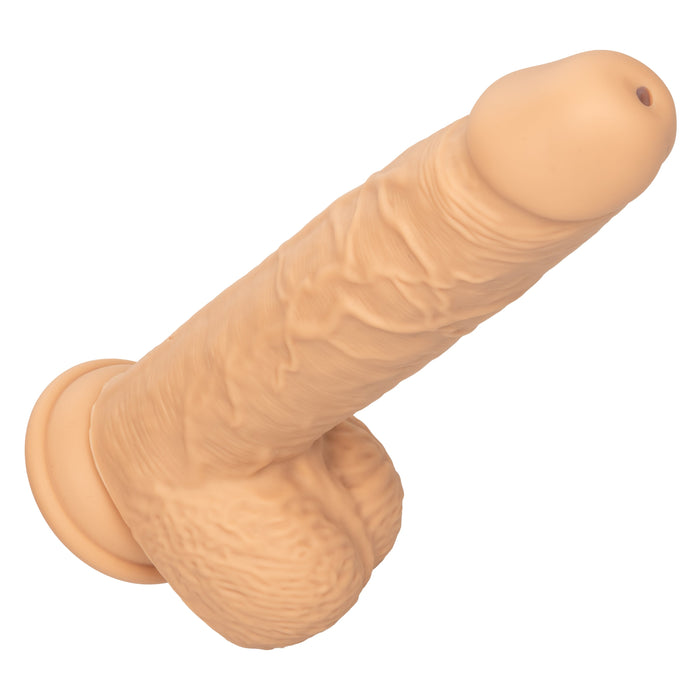 The CalExotics Fuck Stick Squirting Vibrating Silicone Suction Cup Dildo - Vanilla is a beige, realistic-looking dildo with detailed textures and a lifelike design that includes a head, shaft, and testicles. The surface is adorned with prominent veins and folds to enhance its authenticity. It also features a suction cup base for versatile play and is strap-on harness compatible.