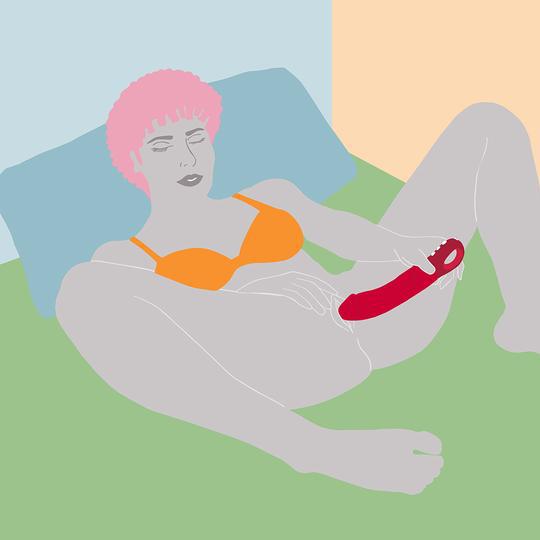 Illustration of a person with short pink hair lying on a bed, wearing an orange bra, holding the Fun Factory Big Boss Thick Vibrator in pink near their lower abdomen. The background consists of pastel-colored walls and a green bedspread.