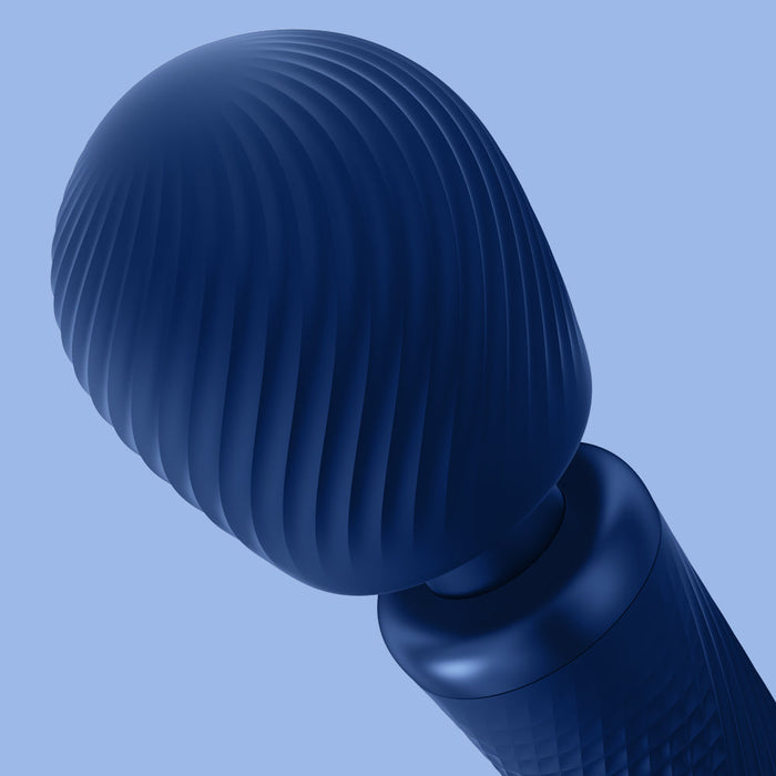 A close-up image of the Fun Factory Vim Silicone Weighted Rumbly Wand Vibrator - Blue against a lighter blue background. The silicone-coated vibrator features a ribbed, dome-shaped surface and a cylindrical handle, hinting at its powerful capabilities.