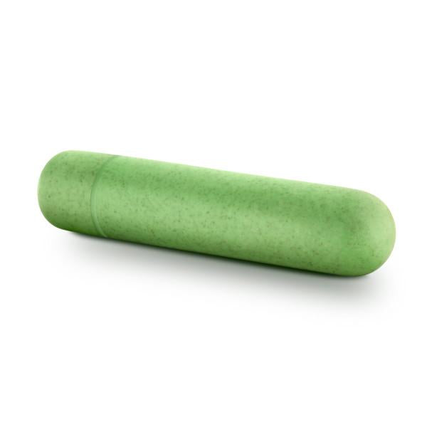 A close-up image of a green cylindrical pill capsule with a smooth, shiny surface. The capsule, resembling the Gaia Biodegradable Recyclable Eco Bullet Vibrator by Blush, is laying horizontally on a white background.