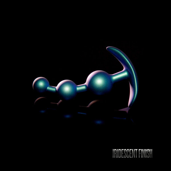 The Gamma Silicone Anal Beads & Butt Plug by Blush, showcasing an iridescent finish with multiple spheres and a curved base against a black background, highlighted with the label "IRIDESCENT FINISH" in the corner.