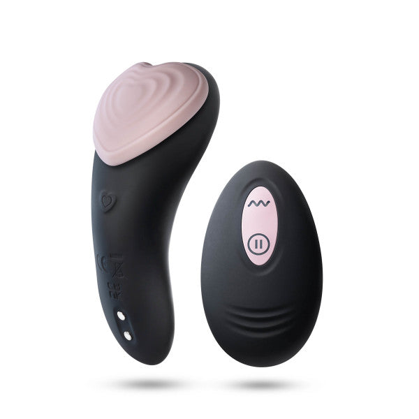 The Heartbeat Panty Vibrator with Remote Control by Blush features a black heart-shaped vibrator with a soft pink tip, crafted from hypoallergenic silicone. It comes with a small black wireless remote control adorned with pink buttons, which include a wave button and a pause/play button. Both items boast smooth, ergonomic designs for optimal comfort.