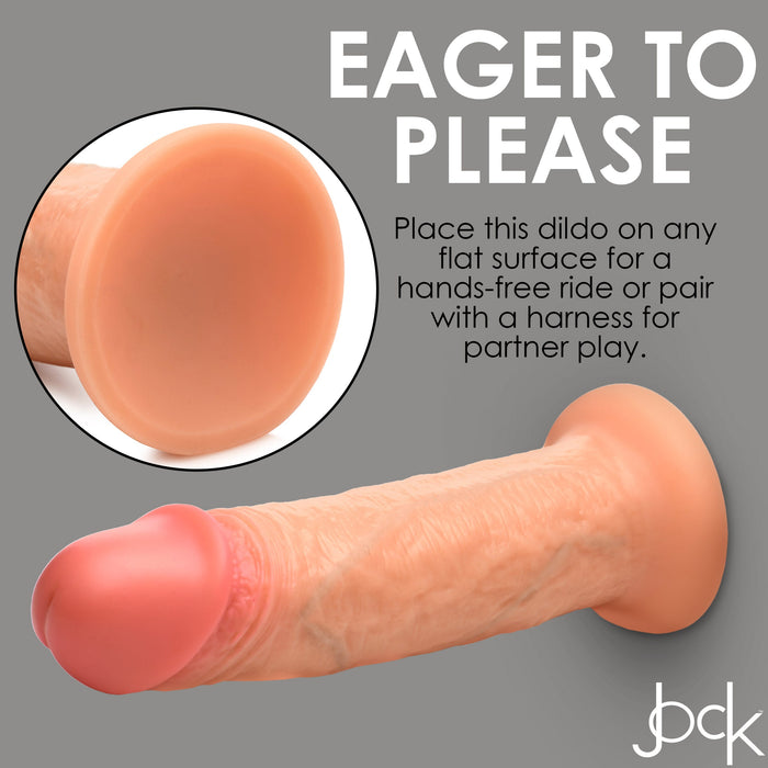 A lifelike dual-density, vanilla-toned dildo with a robust suction cup base is set against a gray background. Text reads: "Eager to Please" and explains how to use the Jock Real Skin 8 Inch Silicone Suction Cup Dildo - Vanilla hands-free or with a harness. The product also features the XR Brands logo in the bottom right corner.