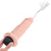 A hand holds a King Cock Realistic Squirting 6 Inch Dildo - Vanilla by Pipedream Products, featuring an ultra-realistic, flesh-colored design with a black base. The toy seems to be ejaculating a white fluid from the tip. The plain white background accentuates the toy and the hand holding it.