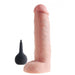 A realistic, King Cock Squirting 10 Inch Dildo with Balls in vanilla, by Pipedream Products, stands upright next to a black bulb-shaped cleaner designed for sex toy hygiene. The dildo features detailed textures mimicking human anatomy.