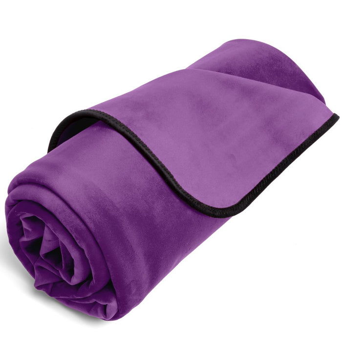 A rolled-up purple Liberator Fascinator Throw Mini Sized Velvety Sex Blanket with a black trim, isolated on a white background.